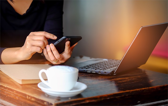 Using phone and laptop at desk